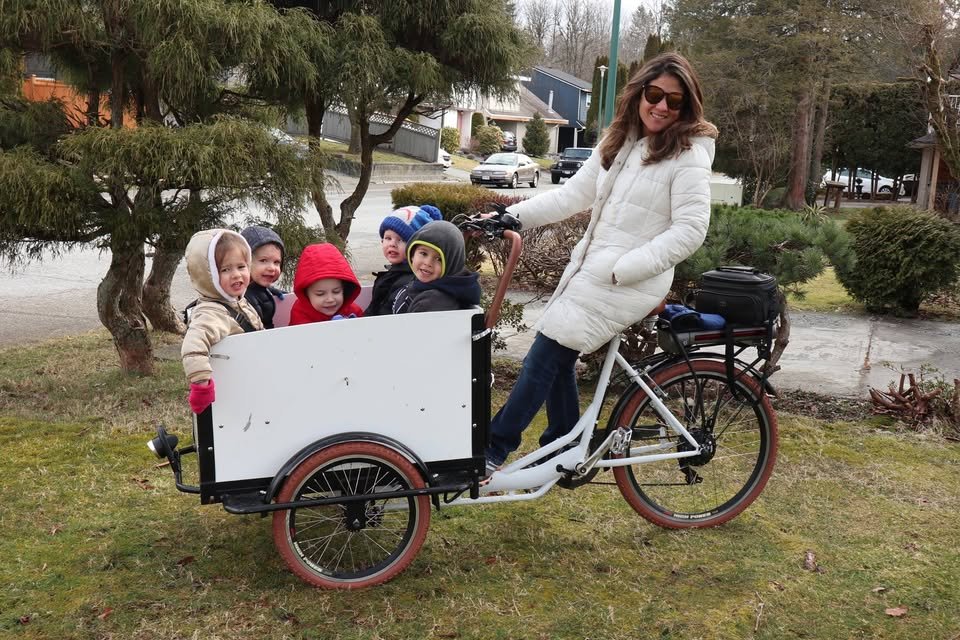 Faviola outdoors with children in a cargo bike