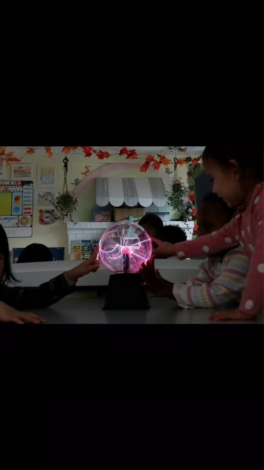 Children touching a plasma ball