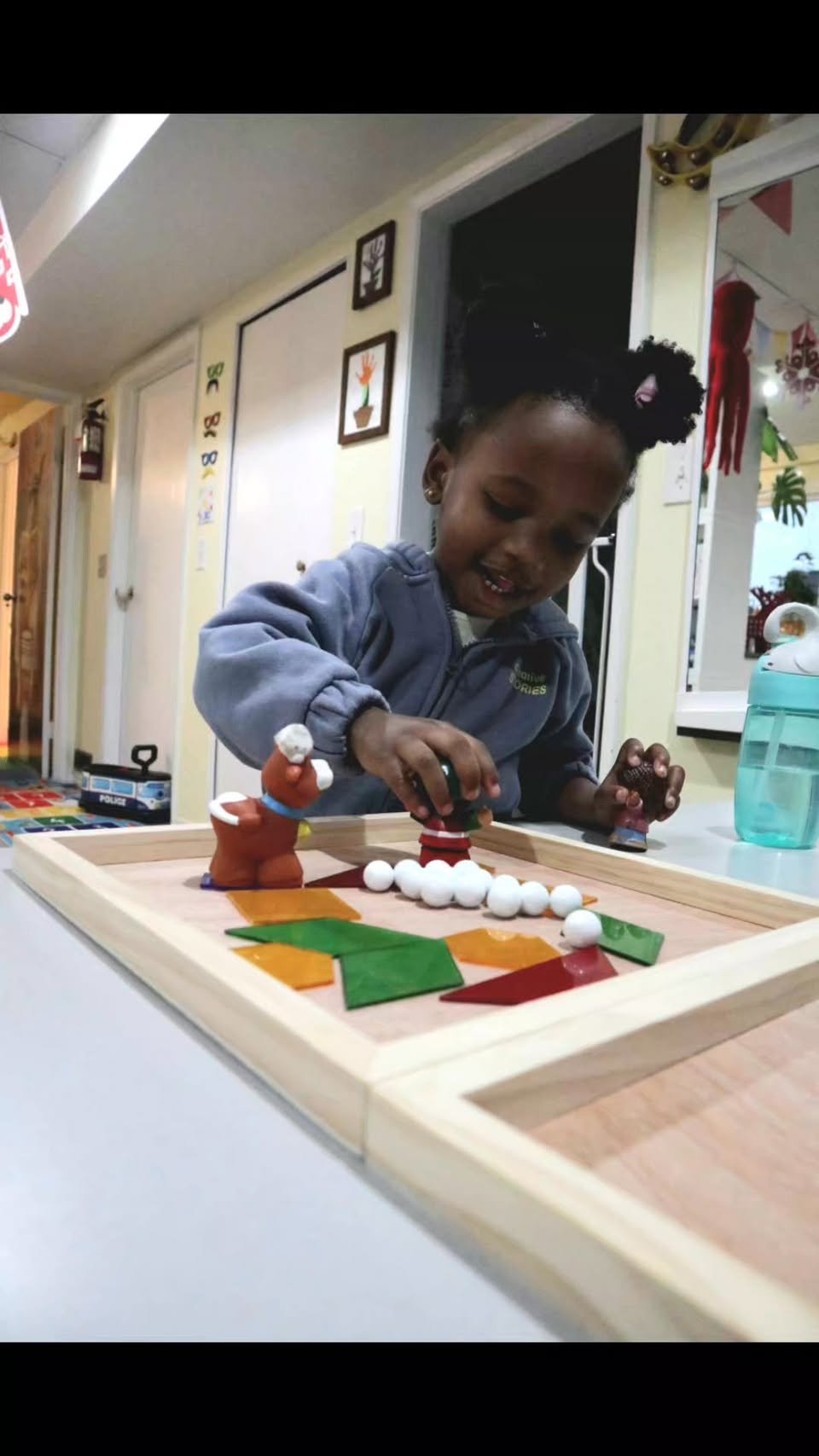 Child playing with magnetic tiles and figures