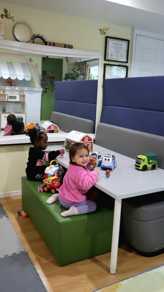 Children playing with toy cars and a farm