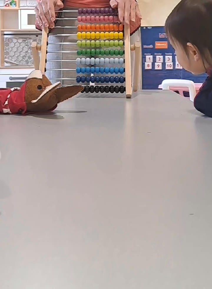 Child playing with a wooden abacus and toy