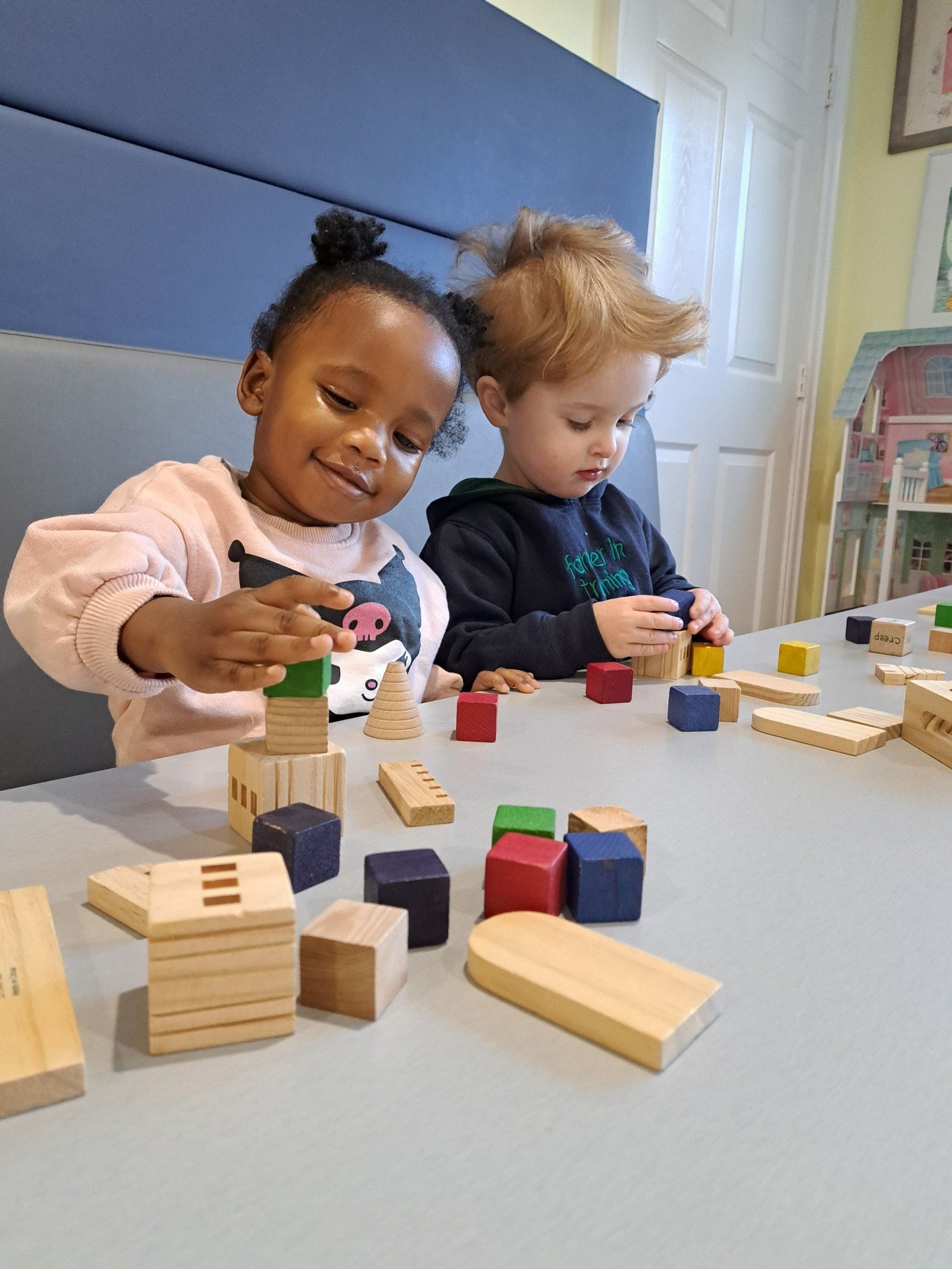 Two children happily playing with building blocks