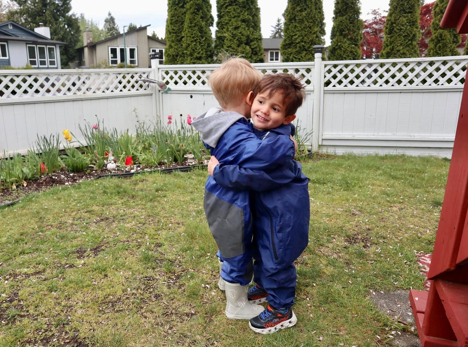 Two young boys hugging each other outside